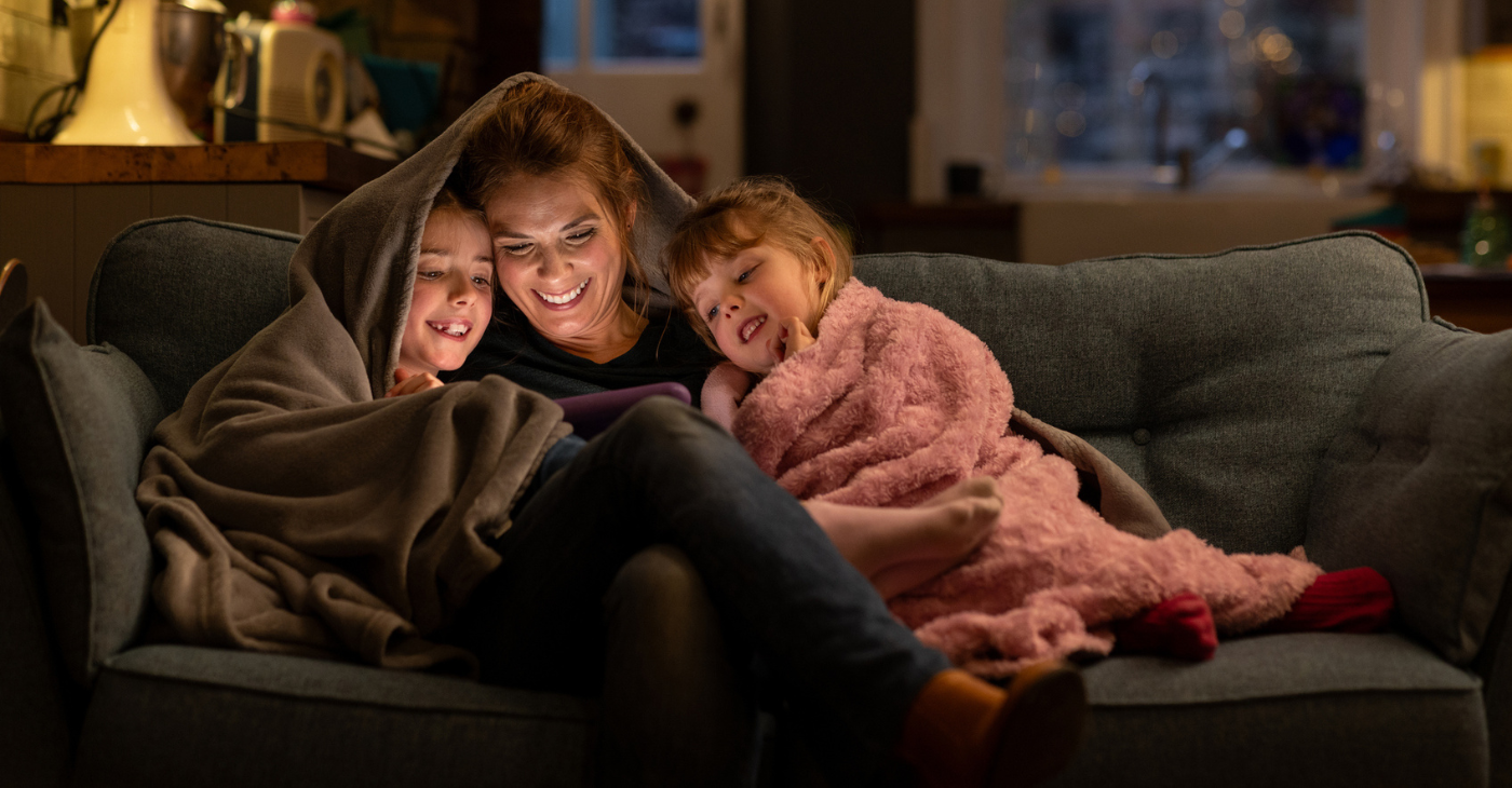Family hugging under a blanket 